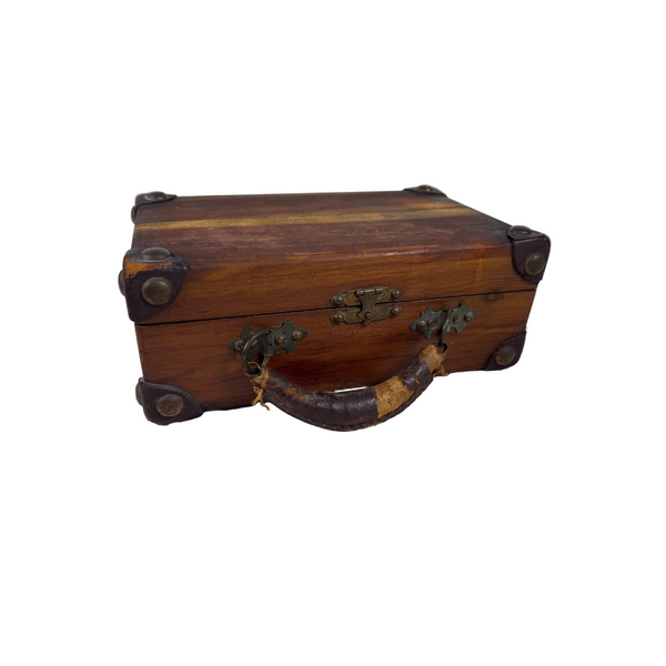 Antique Campaign Shaving Chest Victorian Gentlemans Barbers Travel Case Wood. A vintage wooden jewelry box with a dark brown wood grain finish, antique brass corner protectors and latch, and a curved dark handle with tan wrapping, resting on a white textured fabric surface.