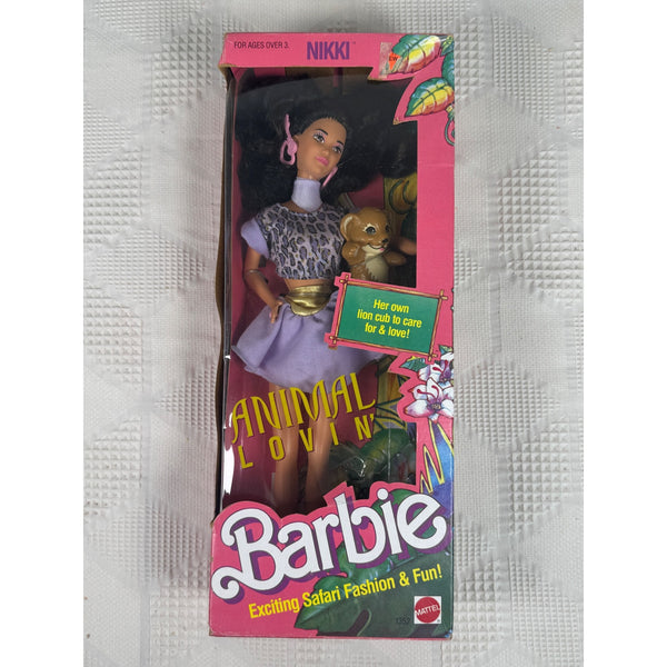 Vintage Barbie Nikki Animal Loving doll in its original pink packaging, displayed on a textured white surface. The box features Barbie's signature branding and colorful safari-themed graphics.