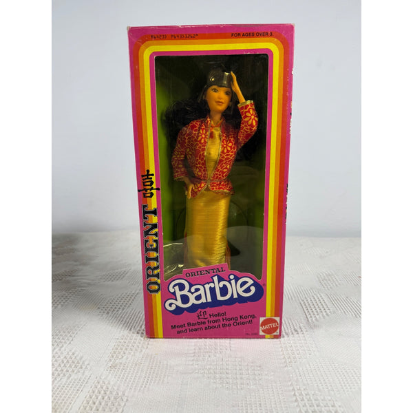 Oriental Barbie doll in its original pink and yellow packaging, featuring a model with long black hair wearing a red patterned jacket and yellow skirt. Oriental Barbie Doll By Mattel Vintage 1980 Hong Kong Theme 3262 NIB