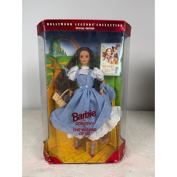 Barbie Hollywood Legends Collection Dorothy Wizard Of Oz Special Edition NIB. Barbie Dorothy The Wizard Of Oz Special Edition doll in its original window box packaging, featuring the blue gingham dress and brown hair doll inside a yellow brick road themed display.