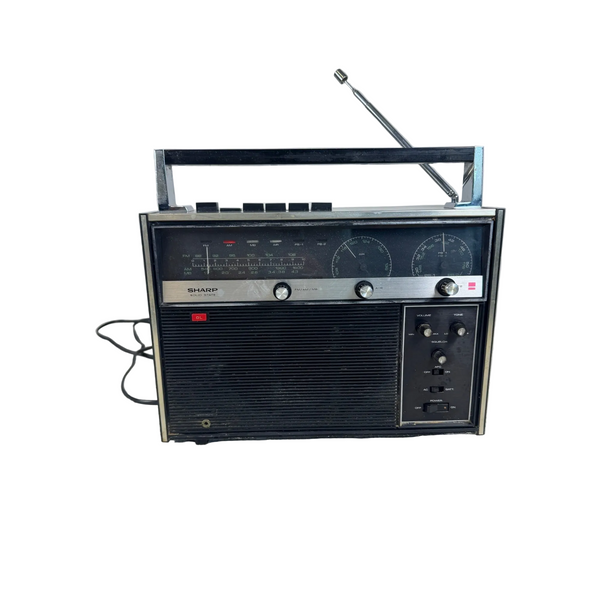 Sharp FV-18U Vintage Solid State Radio 1970s FM/AM/MB/AIR Bands Black Vintage. A vintage SHIKAMI portable radio with a black front grille, silver trim, and an extended metal antenna, sitting on a white textured surface against a light gray background.