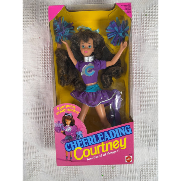 A vintage 1990 Cheerleading Courtney doll in its original packaging, featuring a purple and blue cheerleader outfit with a large 'C' on the shirt, brown hair, and blue/purple pom-poms. Cheerleading Courtney Doll Best Friend Of Skipper Mattel 1992 Vintage 3933 NIB