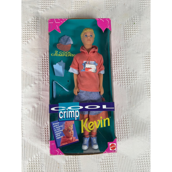 Vintage Mattel 'Cool Crimp' Kevin doll in original box packaging, featuring a blonde boy doll in a coral hoodie and denim shorts with accessories, set against a textured white background. 