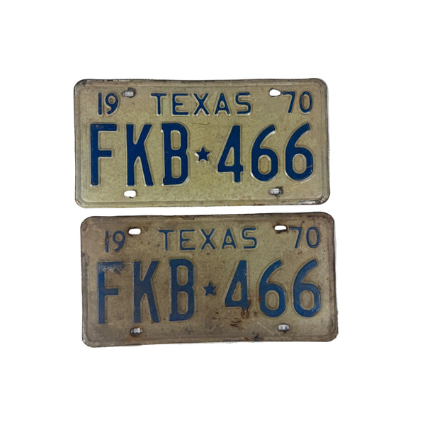 Vintage 1970 Texas License Plates Pair FKB White w Blue Embossed Lettering. Two vintage 1970 Texas license plates with the plate number FKB 466, displayed vertically on a textured white fabric background.