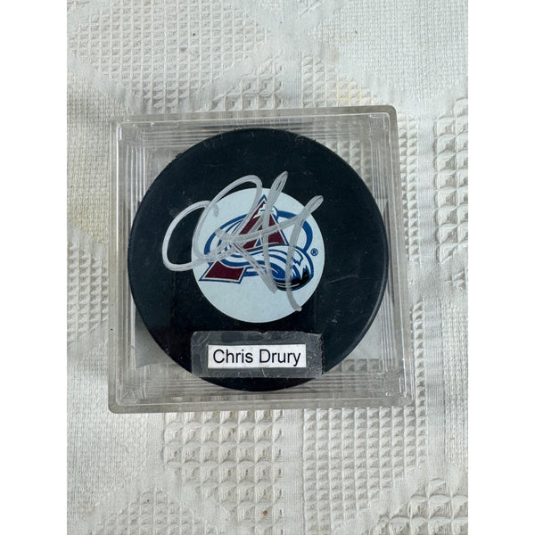 Chris Drury Autographed Colorado Avalanche Hockey Puck Certificate Authenticity. An autographed Chris Drury Colorado Avalanche hockey puck inside a clear acrylic display case, set against a textured white background.