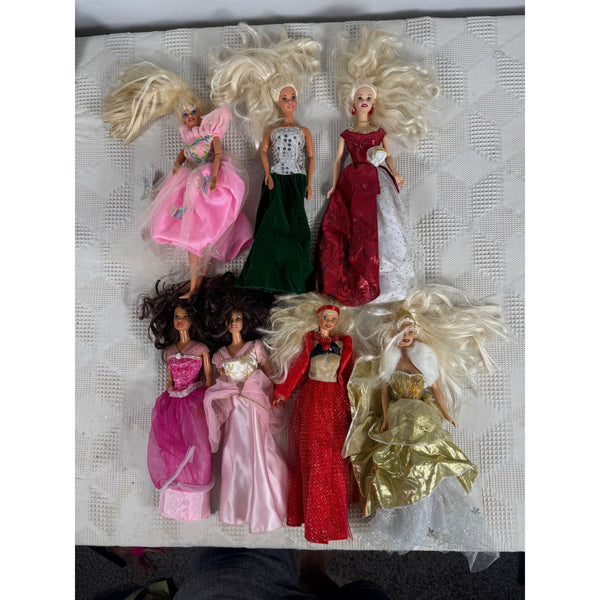 Lot of 7 Barbie Dolls Princess Elegant Gowns Collection Vintage 1990 to 2000. A collection of eight vintage fashion dolls with long blonde and dark hair, dressed in various colorful evening gowns, arranged on a white textured fabric surface.