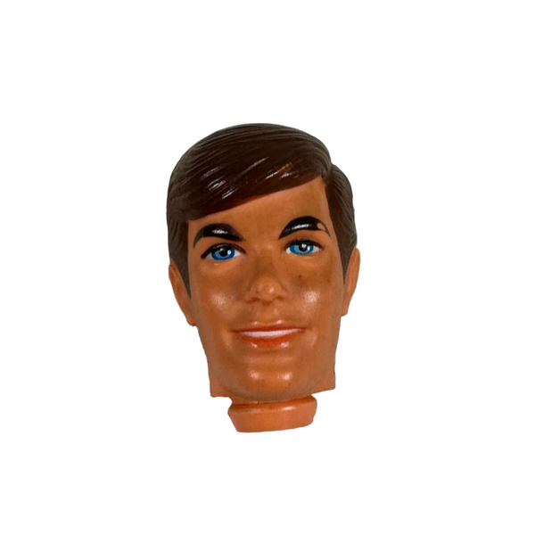 Ken Doll Replacement Head Brown Hair Blue Eyes Vintage 1968 Barbies Boyfriend. A vintage plastic doll head with brown hair, a tan face, and blue eyes, resting on a textured off-white fabric background.