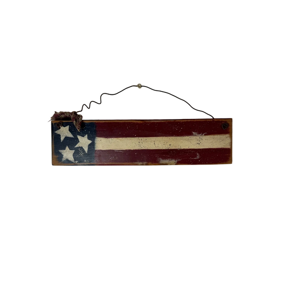 Rustic Handmade Wooden Patriotic Flag Wall Decor Wire Hanger Country Farmhouse. A rustic, rectangular wooden wall hanging depicting a distressed American flag design with three white stars on a blue canton, red and off-white stripes, and a black wire hanger at the top, shown against a plain light gray wall.