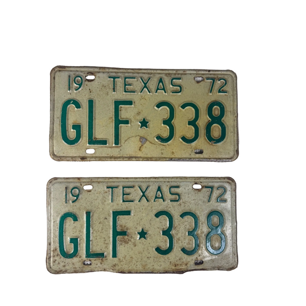 Vintage 1972 Texas GLF 338 License Plates Pair Green w White Embossed Lettering. Two vintage 1972 Texas license plates with the plate number GLF 338, displayed vertically on a white textured fabric background.