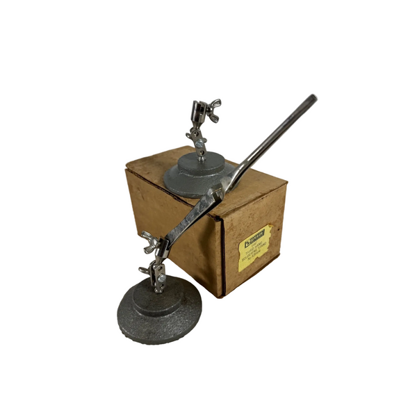 HR Superior Peer Third Hand Soldering Stand Pair w Adjustable Clamps and Tweezer. A vintage metal desk lamp with a circular base and long arm, shown standing in front of its brown cardboard box on a textured white surface against a light gray background.