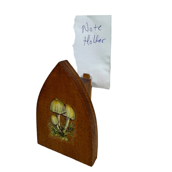 Vintage Wooden Note Photo or Recipe Holder w Clothes Iron Shape Mushroom Design. A wooden note holder with a mushroom illustration, holding a piece of paper that says 'Note Holder'.