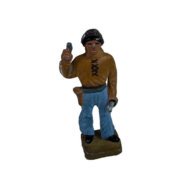 Vintage Treasure Chest Miniatures Lead Cowboy Figurine Wild West Frontier . A small hand-painted toy soldier figurine wearing a brown shirt, blue pants, and a black cap, standing on a textured off-white surface.