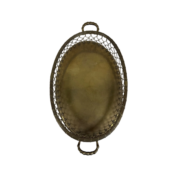 Vintage Mid Century Brass Oval Serving Basket Tray Mesh Sides Hollywood Regency. An oval metal serving tray with a hammered finish and wire mesh sides, featuring two loop handles, shown on a textured white surface.