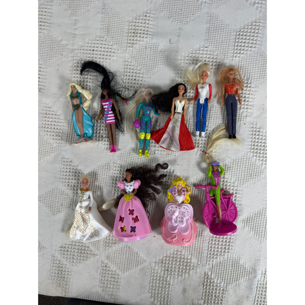 Lot of 10 McDonalds Barbie Happy Meal Toys Vintage 1990s Collectibles. A group of vintage Barbie-style doll figures and accessories arranged on a white textured fabric surface. The set includes multiple dolls with different hair colors and outfits, along with a pink bicycle accessory.