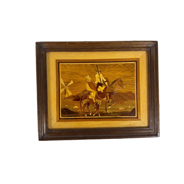 Vintage Marquetry Wood Framed Art Featuring Don Quixote and Sancho Panza  c1960s. A framed wooden inlay artwork depicting a cowboy riding a horse with a windmill in the background, set against a textured white fabric backdrop.
