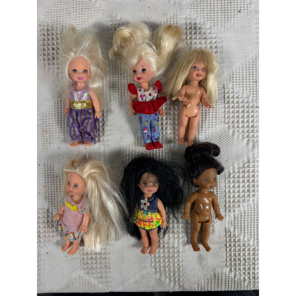 Vintage Lot of 6 Kelly and Friends Dolls 1990s Mixed Outfits and Styles. Six small plastic dolls with long blonde, brown, and black synthetic hair, arranged on a white textured paper towel. The dolls wear various colorful outfits, including purple pants, a red dress, and floral tops.