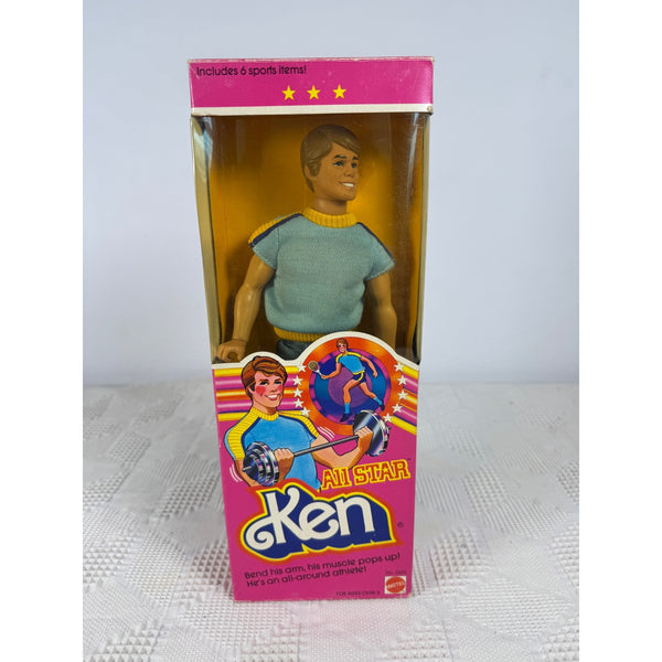 Vintage Mattel Ken All Star plastic doll in its original pink and yellow retail packaging, photographed against a neutral light gray. All Star Ken Doll 1981 By Mattel Includes 6 Sports Items Vintage Toy 3553 NIBbackground.