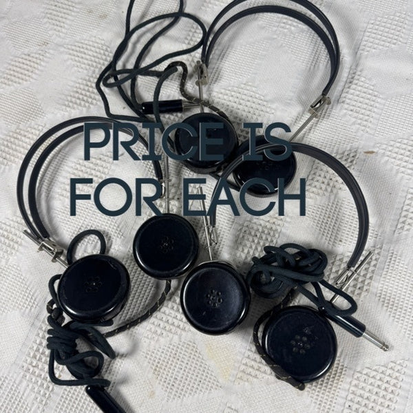 Several black oval-shaped wired devices with attached cords and small metal plugs, arranged on a white textured fabric background. Large overlaid text reads 'PRICE IS FOR EACH'.