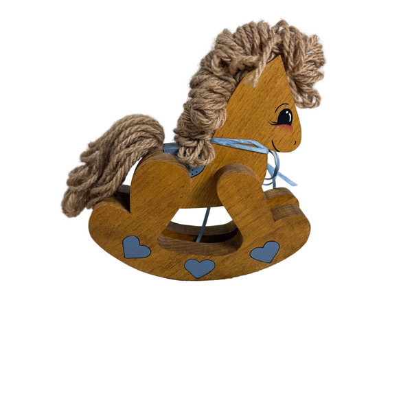A wooden rocking horse toy with a brown rope mane and tail, painted blue hearts on the rockers, and a light blue ribbon around its neck, set against a white textured background.