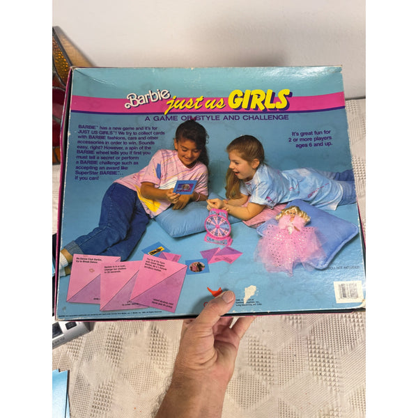 Barbie Just Us Girls Board Game Vintage 1989 By Cardinal Complete Set Retro . A hand holding a vintage Barbie 'Just as Girls' game box, showing the back cover with two children playing and pink game pieces illustrated on the box.