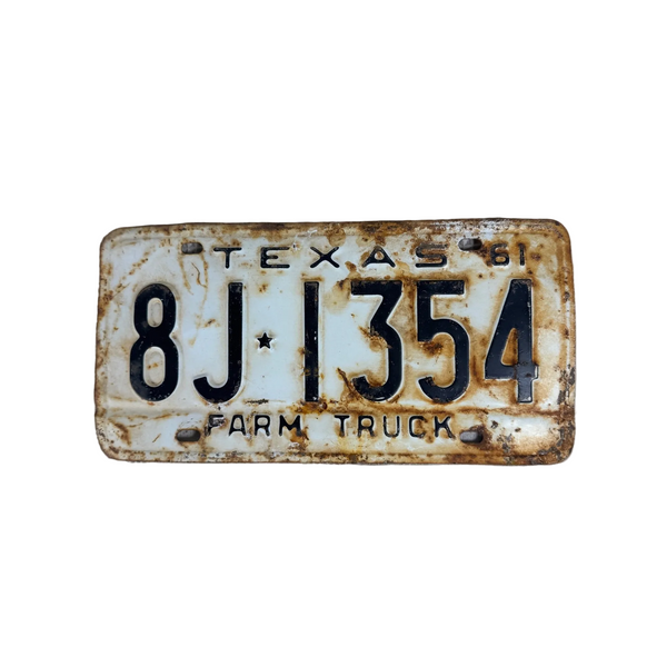 Vintage 1961 Texas Farm Truck License Plate 8J 1354 White Black Embossed Text. A vintage distressed Texas Farm Truck license plate reading 8J1354, featuring a weathered white background with heavy rust and wear, photographed on a textured white surface.