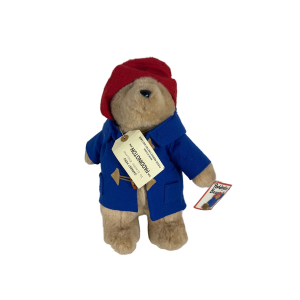 Paddington Bear Plush 2002 Beverly Hills Teddy Bear Co Blue Coat Red Hat w Tags . A plush teddy bear dressed as Paddington Bear, wearing a red beret and blue jacket, with a hangtag attached, set against a plain light gray wall and textured gray surface.