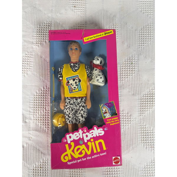 Vintage Mattel Pet Pals Kevin doll in its original pink window box packaging, featuring a male doll dressed in a yellow shirt and black-and-white patterned shorts, with a small Dalmatian dog figure. Pet Pals Kevin Doll With Dalmatian Puppy and Doghouse 1991 By Mattel 2711 NIB