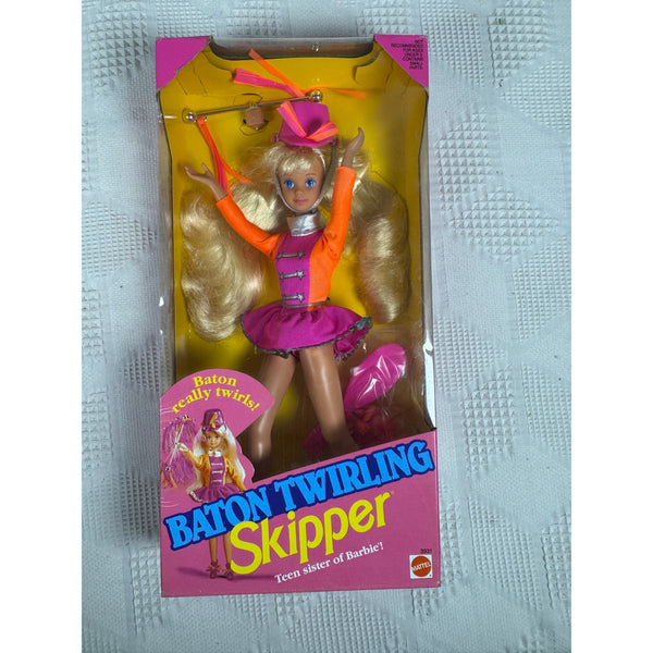 Vintage Baton Twirling Skipper toy doll in its original packaging, featuring a blonde doll dressed in a pink and orange twirling outfit, displayed on a textured light gray surface.