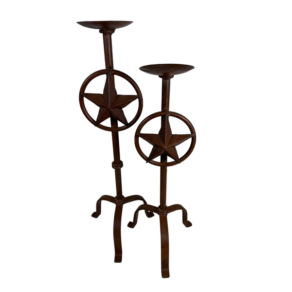 Rustic Iron Texas Star Candle Holders Set Of 2 Western Style Decor Rust Finish . Two rustic dark brown metal candlestick holders with star and wheel designs, standing on a textured white surface against a light gray background.