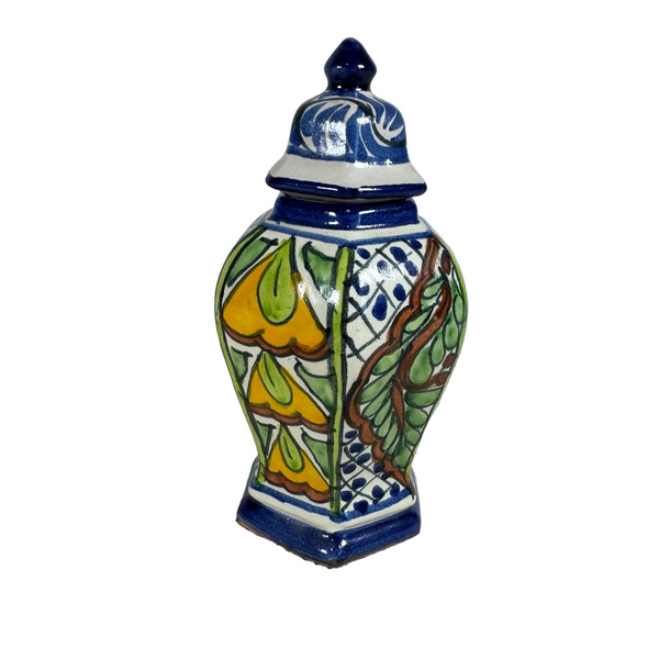 Handcrafted Talavera Ceramic Lidded Ginger Jar w Colorful Floral Design Mexico . A hand-painted ceramic lidded jar with a blue and white base, decorated with yellow, green, and brown floral and leaf patterns, set on a textured white surface against a light gray background.