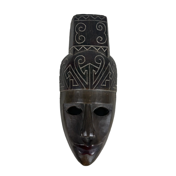 Hand Carved Wooden Mask w Intricate Patterns from Temor Indonesia Wall Hanging. A dark carved wooden mask with geometric patterns on a textured white background.