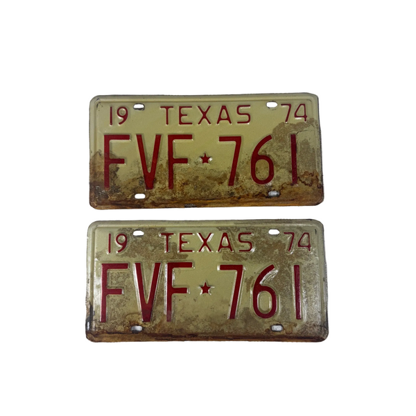 Vintage 1974 Texas License Plates Pair FVF 761 White w Red Embossed Text . Two vintage 1974 Texas license plates with red lettering and a yellow-tan background showing signs of rust and age, displayed on a white textured fabric background.