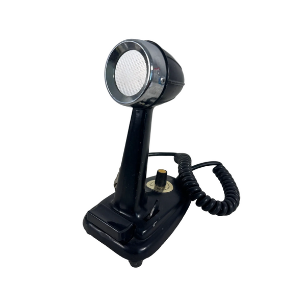 Vintage Desk Bullet Style Microphone with Adjustable Volume Knob & Coiled Cable. A vintage black and chrome desk telephone receiver with a coiled cord, resting on a textured white fabric surface.