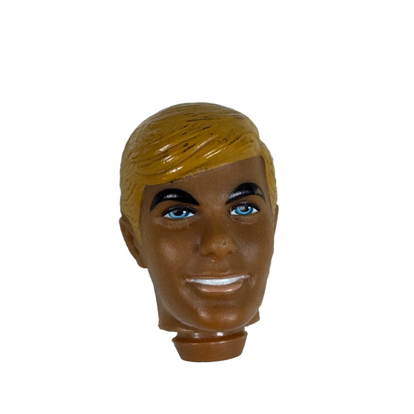 Vintage 1968 Malibu Ken Doll Replacement Head Blonde Hair Blue Eyes Mattel. A vintage plastic Ken doll head with blonde hair, brown skin, and blue eyes, resting on a textured white waffle-knit fabric background.