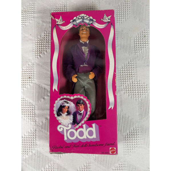 A vintage Mattel 'Todd' Barbie doll in its original pink packaging, displayed on a textured white fabric background. The box features a photo of the doll dressed in a purple suit and gray pants. Todd Barbie Groom Doll 1982 Mattel 4253 Vintage Wedding Edition 4253