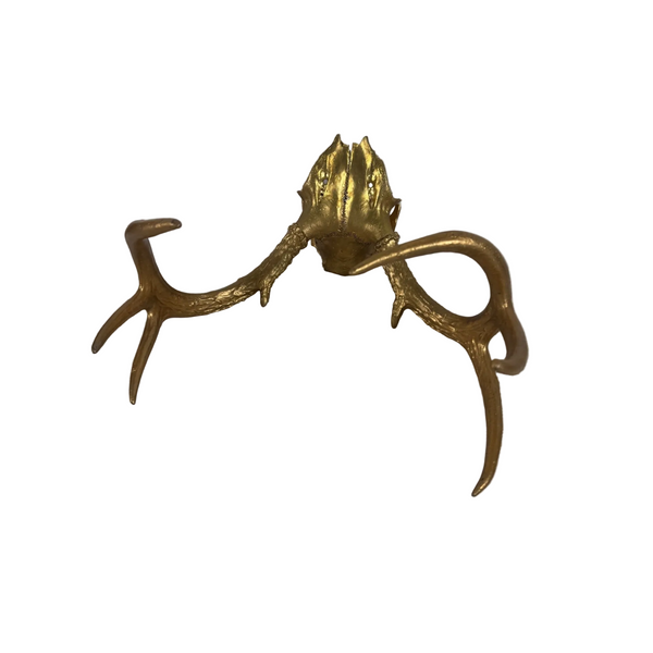 Gold Finished Deer Antlers With Partial Skull Mount Wall Decor Modern Farmhouse. A decorative wall-mounted deer antler sculpture in a metallic gold finish, displayed against a light gray wall and white textured fabric backdrop.