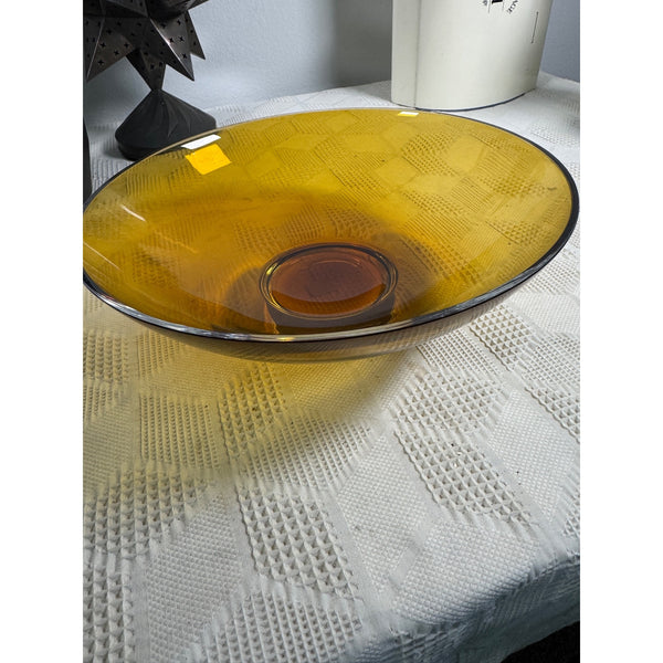 Amber Glass Waterlily Bowl by Crate & Barrel Decorative Centerpiece Made Turkey (gently used). A translucent amber yellow glass bowl with a textured geometric pattern, resting on a white textured tablecloth.