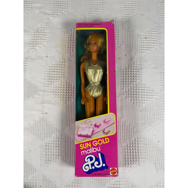 Vintage P.J. Sun Gold Malibu doll in its original pink and yellow packaging, displayed on a textured white fabric background. Sun Gold Malibu PJ Doll Vintage 1983 With Accessories By Mattel 1187 NIB