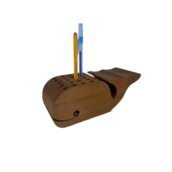 Wooden Whale Shaped Pen or Pencil Holder w 24 holes for Desk Organization Decor. A wooden whale-shaped desk organizer holding two pens, one yellow and one blue, set on a textured white fabric surface against a plain light gray background.