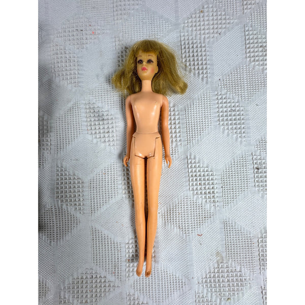 Vintage 1960s Mattel Francie Doll Friend of Barbie Fringe Eyelashes TNT Bendable. A vintage blonde doll with a tan plastic body and hair, lying on a textured white fabric background.