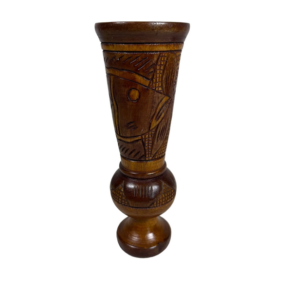 Hand Carved Wooden Vase With Polynesian Style Fish and Floral Design Vintage. A carved wooden vase with a flared rim and a bulbous base, featuring geometric and abstract patterns, shown on a textured white surface against a light gray background.