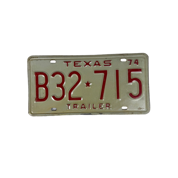Vintage 1974 Texas Trailer License Plate B32 715 Red Embossed letters on White. A vintage-style Texas trailer license plate with red lettering and numbers on a cream-colored background, placed on a textured white surface.