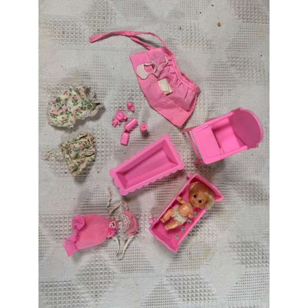 Vintage 1973 Mattel Baby Sweets Doll Set w Clothes Accessories Sunshine Family . A pink doll playset arranged on a textured white fabric background, including a bassinet with a doll, clothing pieces, accessories, and a small pink container.