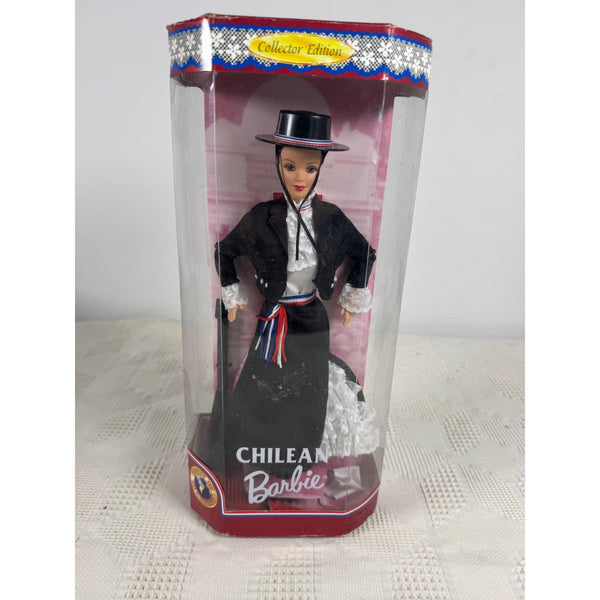 A Chilean Barbie doll in its original packaging, wearing a traditional black dress with a white shirt and a black top hat, set against a light gray background. Chilean Barbie Dolls Of The World Collector Edition 1997 Mattel 18559 NIB