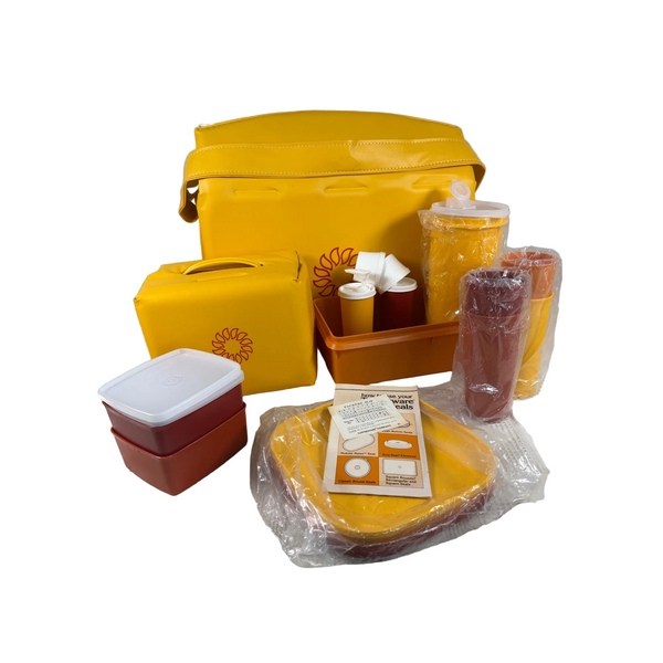 Vintage Tupperware Picnic Set w Containers and Carrying Bags 1980s Starburst NEW. A vintage 1970s or 1980s 5-piece toy picnic set in bright yellow and terracotta red, displayed on a white checkered tablecloth. The set includes a large cooler bag, a smaller lunch box, a cup with a straw, a cup with a lid, a plastic container, and a plastic plate, with some accessories and an instruction booklet.