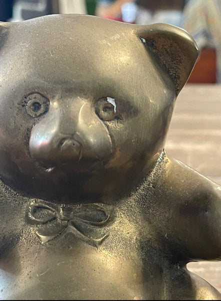 Vintage brass bear bookends up close view of the chip around the eye of bookend 2