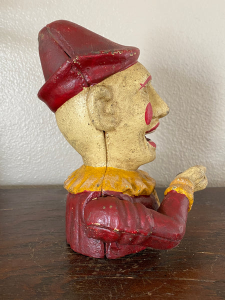 Antique Iron mechanical clown bank, side view with lever up.